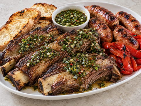 Asado Feast (coaste de vită la grătar și cârnați de porc cu chimichurri) Asado Feast (coaste de vită la grătar și cârnați de porc cu chimichurri)