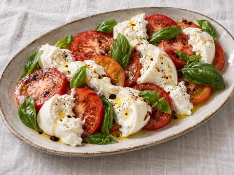 Sałatka pomidorowa z burratą i bazylią w stylu caprese Sałatka pomidorowa z burratą i bazylią w stylu caprese