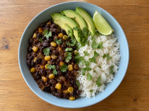 Bowl di riso con fagioli neri piccanti in stile latino con avocado e lime