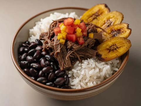 Pabellón Criollo -kulho (venezuelalainen revitty naudanliha riisin, papujen ja jauhobanaanin kanssa) Pabellón Criollo -kulho (venezuelalainen revitty naudanliha riisin, papujen ja jauhobanaanin kanssa)