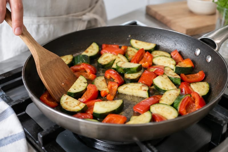 Vegetables sautéing in a single layer with room between the pieces. Vegetables sautéing in a single layer with room between the pieces.
